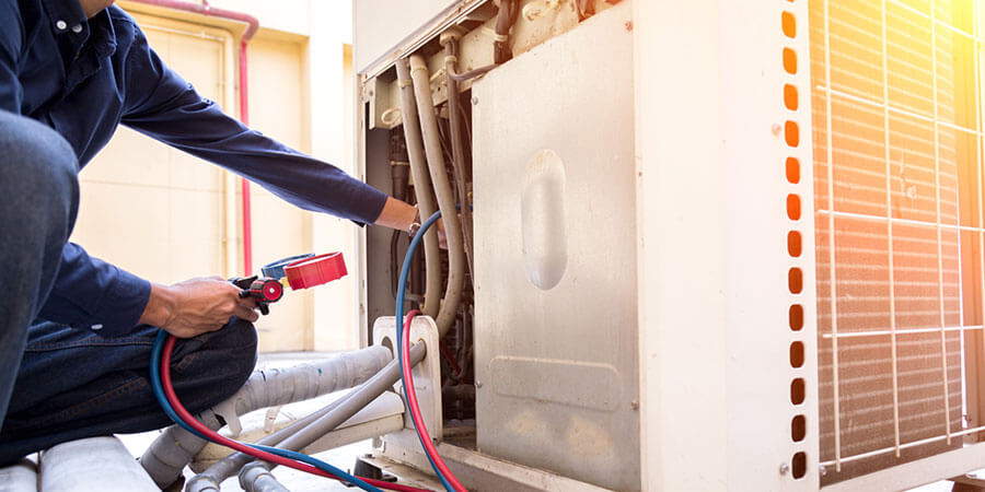 hvac technician repairing commercial ac unit